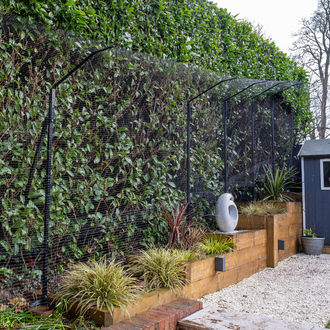 cat enclosure in front of hedge